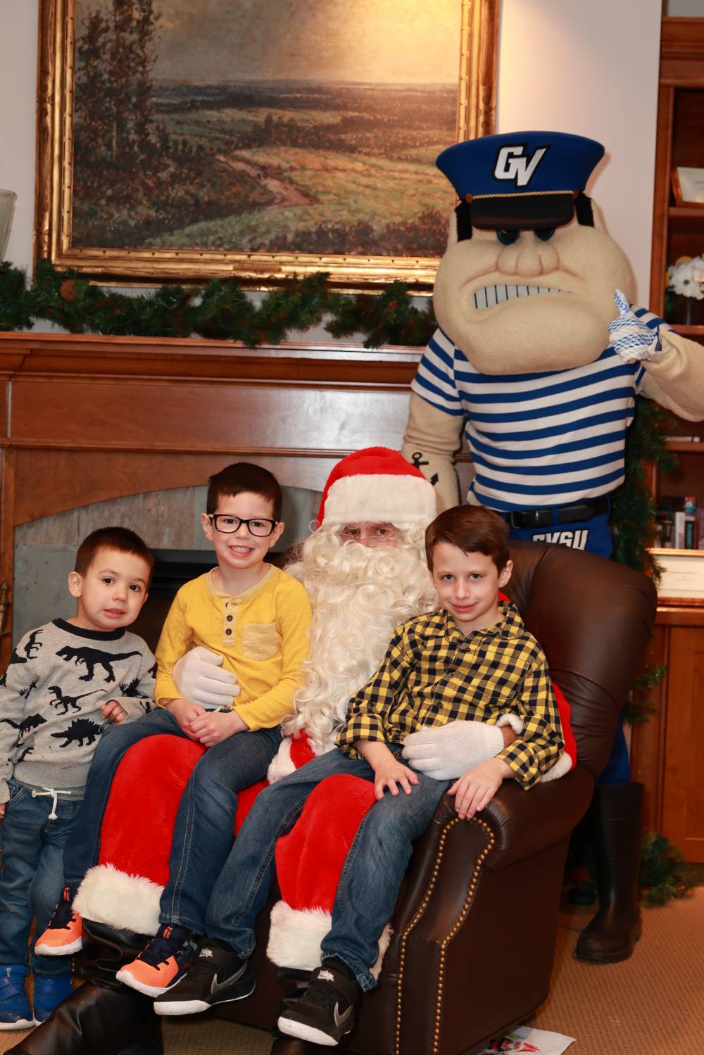 Three boys sitting with Santa & Louie.